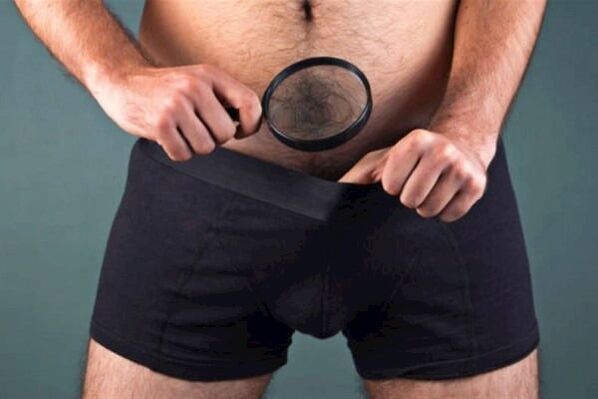 a man with a magnifying glass examines his penis and wants to thicken it